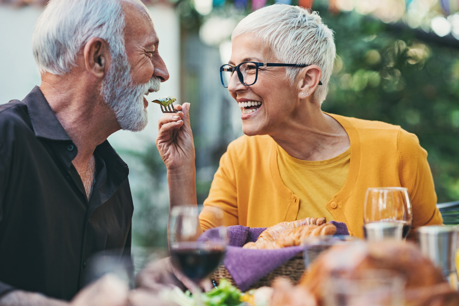 Woman feeding man salad